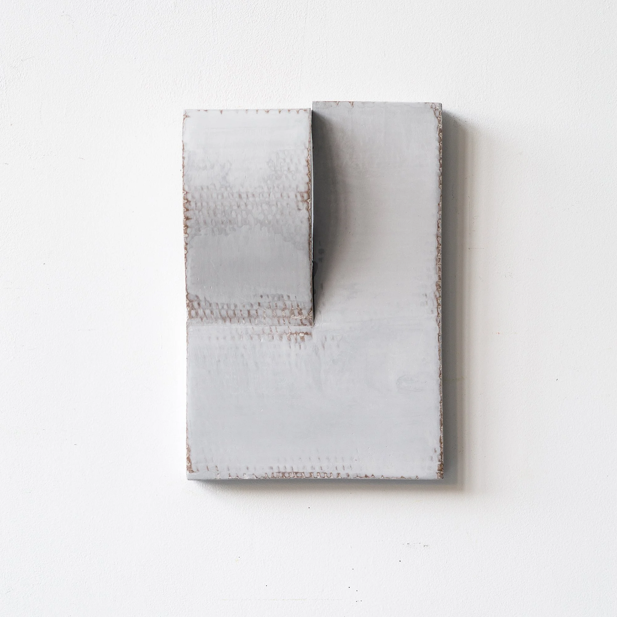 SOLD

Abstract grey sculpture with geometric shapes on a wall
