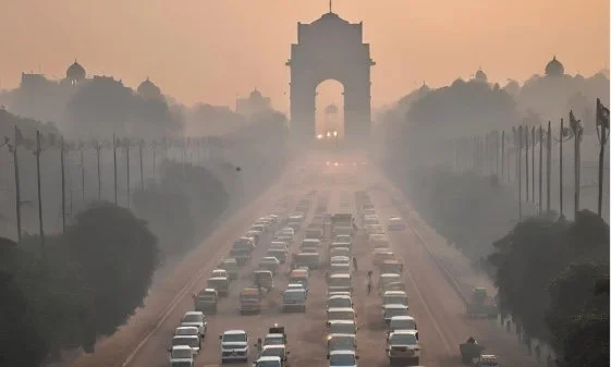 Traffic at India Gate in Delhi, with air full of haze.