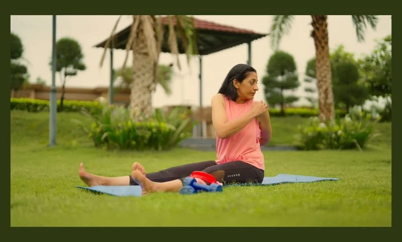 A mid-age woman doing yoga in her lawn