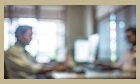 A hazy image two professionals at their office desk.