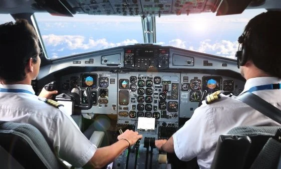 Two pilots in the cockpit of a plane.