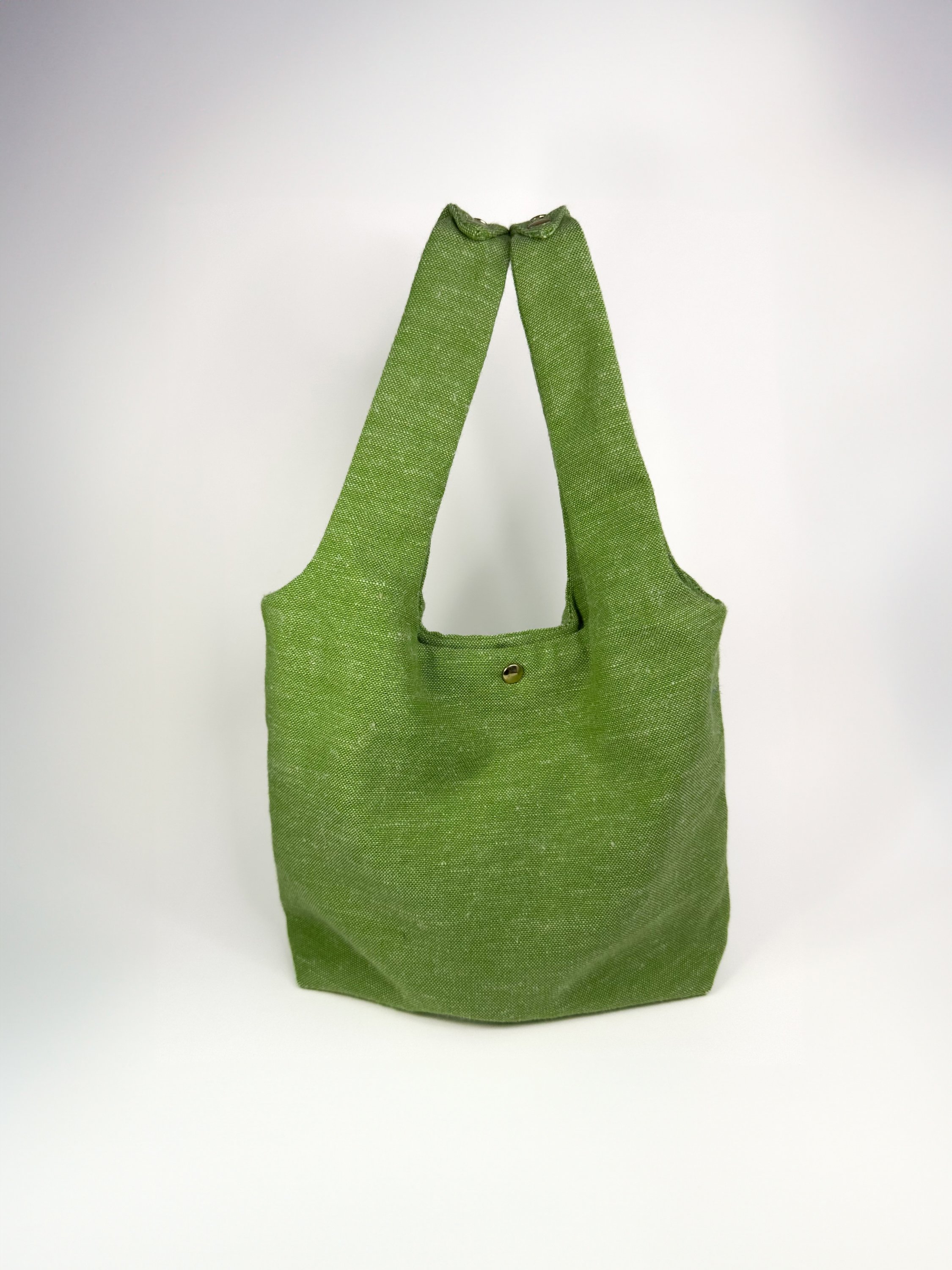 Grass green linen fairy bag with gold rivets, soft structure and reversible