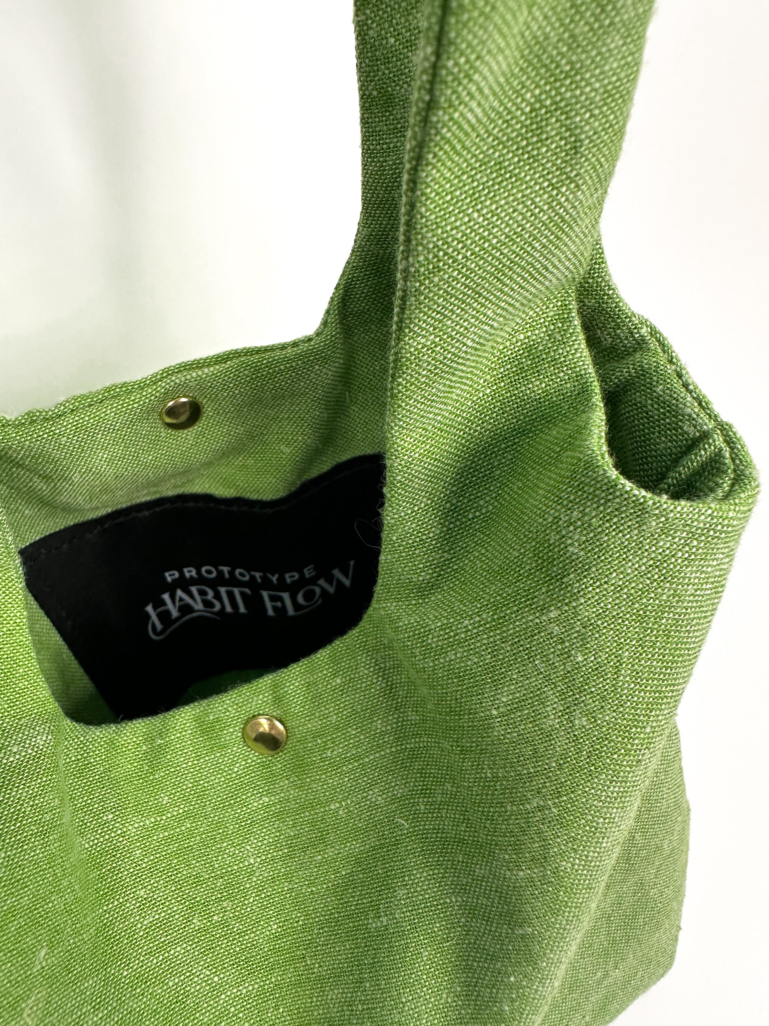 Detail shot of garden green 100% linen fairy bag with gold rivets,