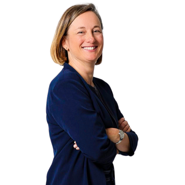 Frau mit brünettem harr und verschränkten Armen lächelt in Kamera