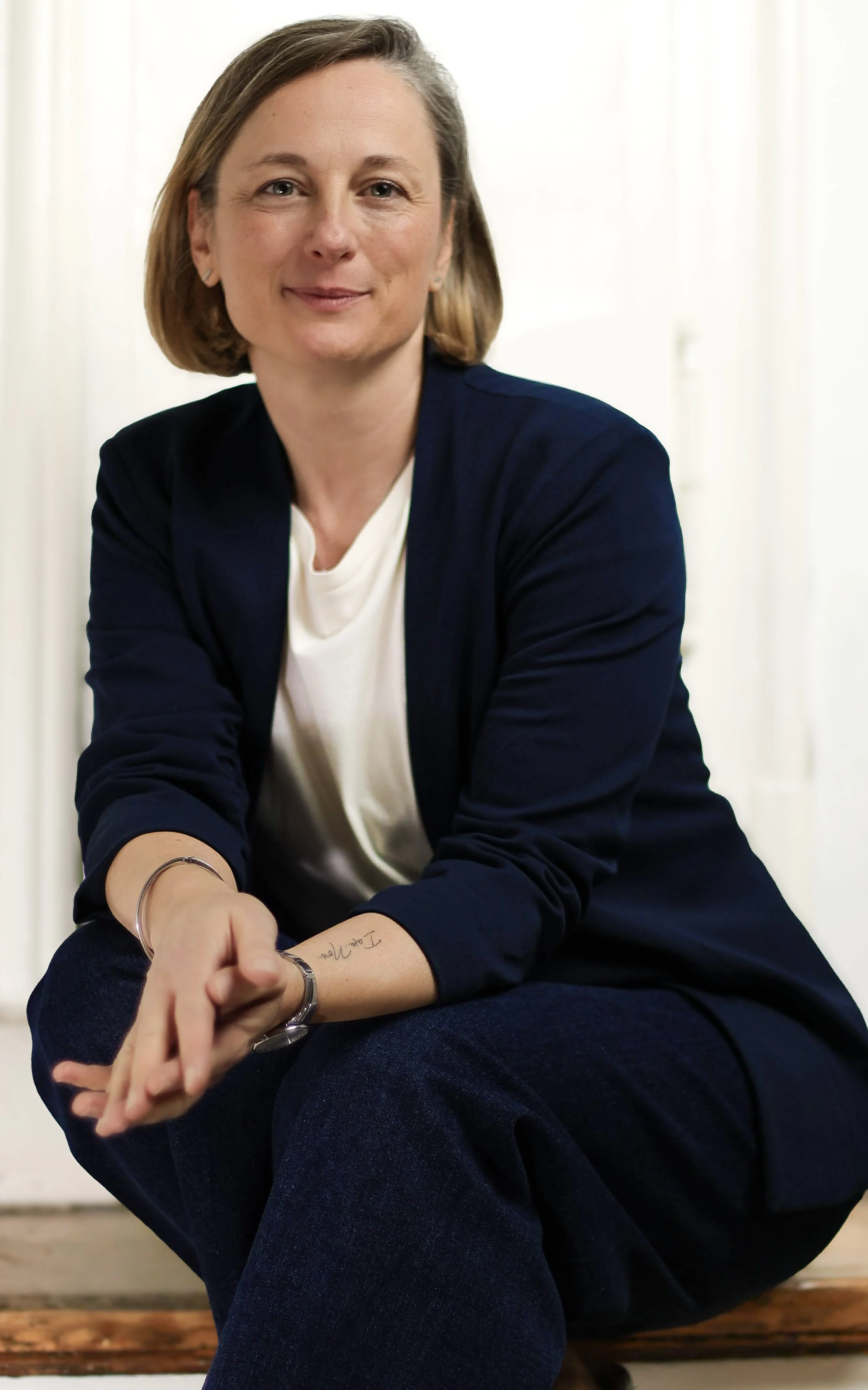 Frau mit habllangem braunem Haar sitzt auf einer Treppenstufe