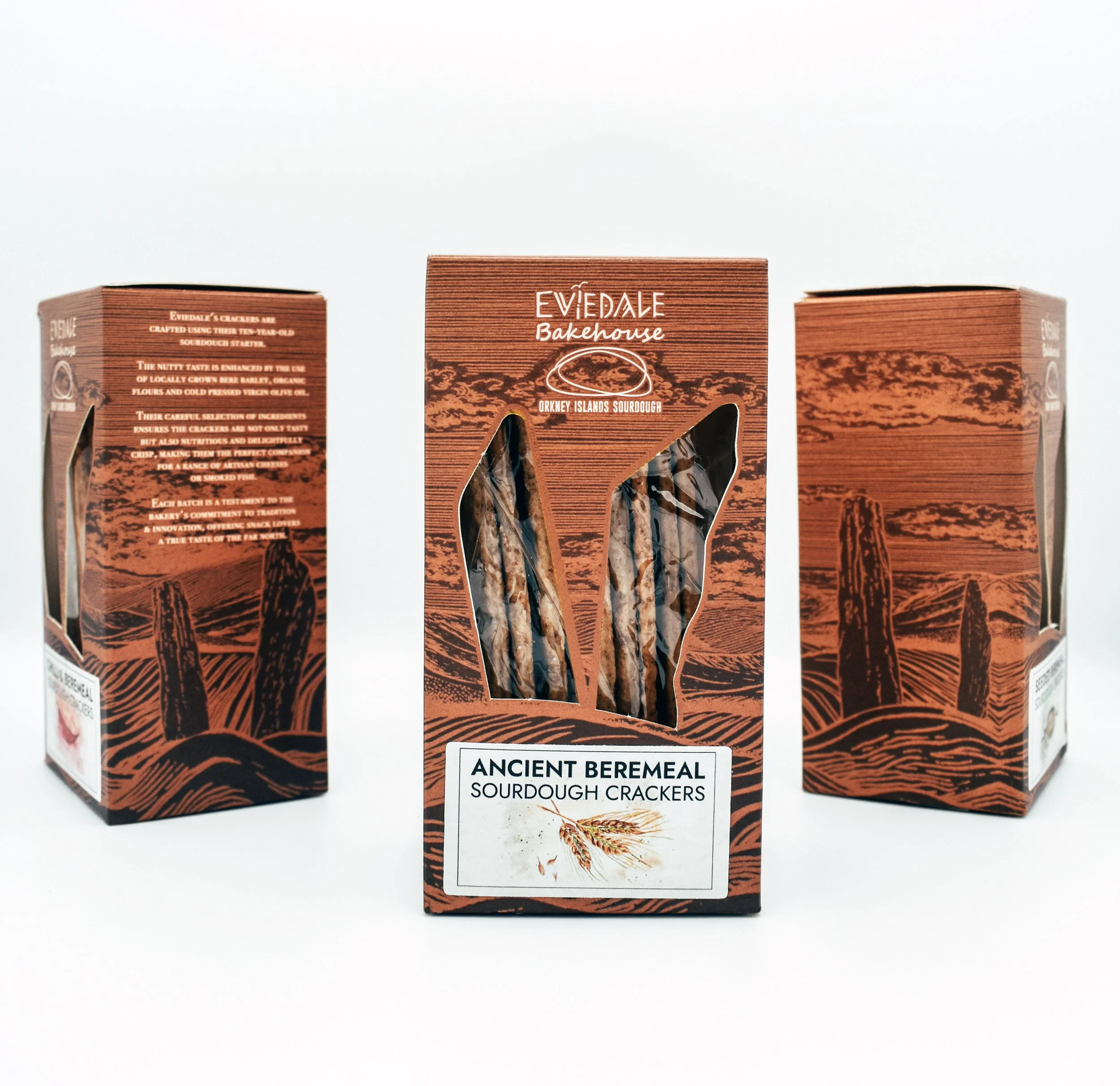 Three boxes of Ancient Beremeal sourdough crackers from Evidale Bakehouse, with the middle box displaying a small illustration of wheat on the front.