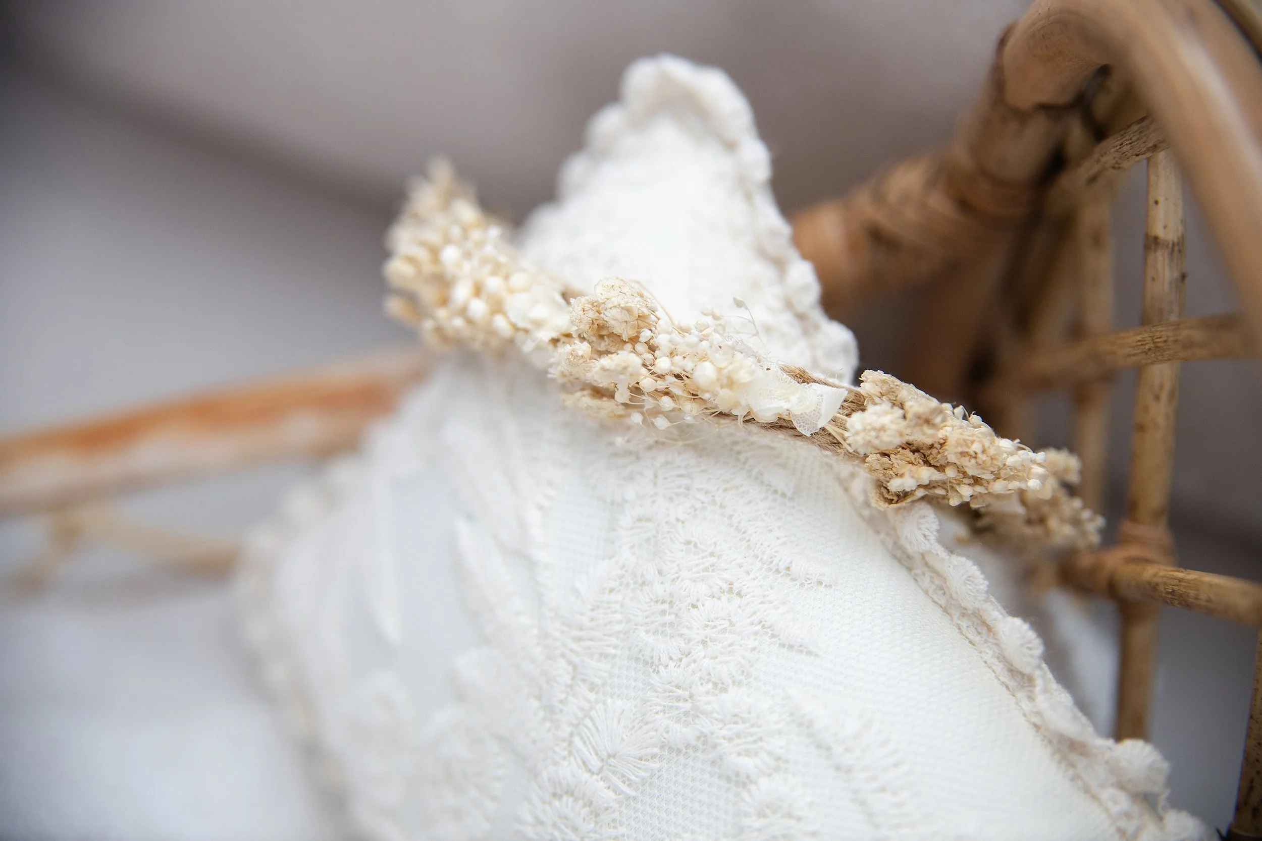 Neutral baby bonnet and wrap styled on wooden prop for newborn photography session in Rochester Hills Michigan studio