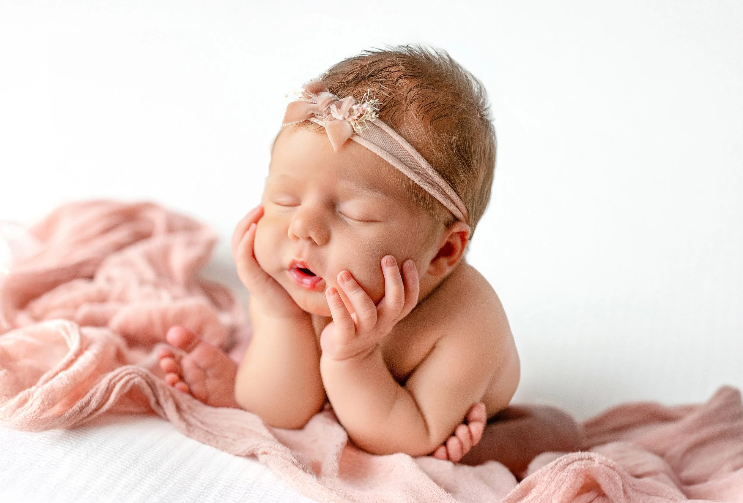 Newborn baby girl sleeping with pink headband photographed by Rochester Hills newborn photographer El & Em Photography