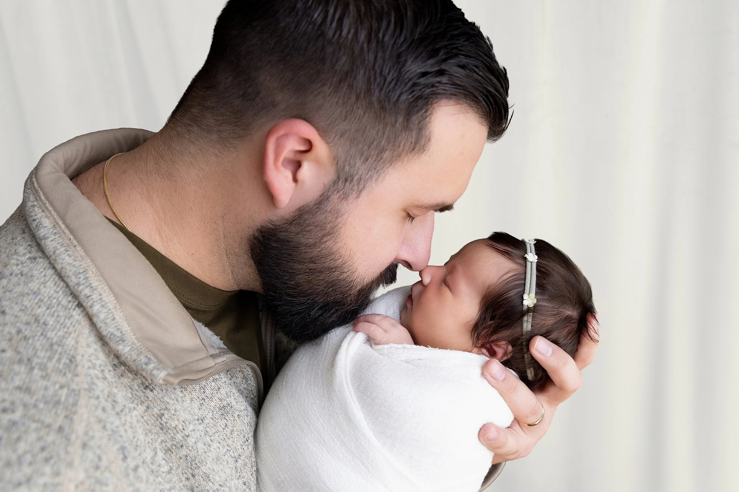 Father holding newborn baby during a Rochester Hills newborn photography session at El & Em Photography