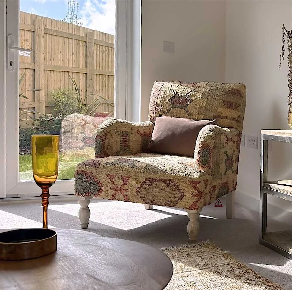 lounge with upholstered chair in aztec inspired pattern jute in earth colours  and wood turned legs