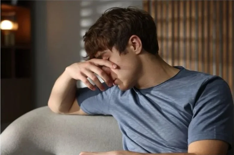 Teen boy hiding his face