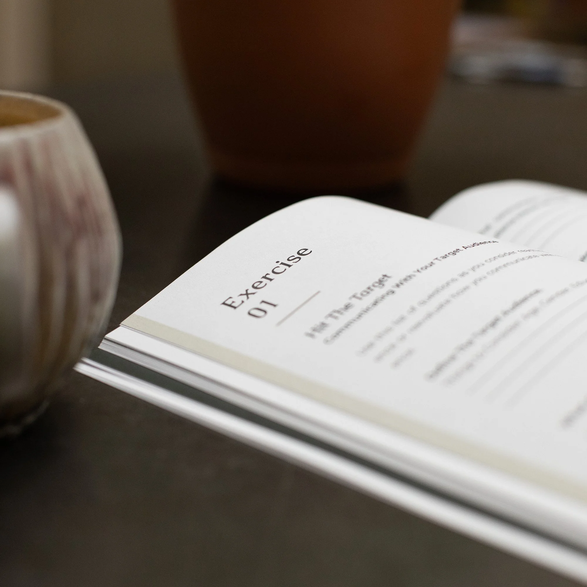 Close-up of printed pages with the word 'Exercise' visible, resting on a dark surface, with a blurred object in the background.