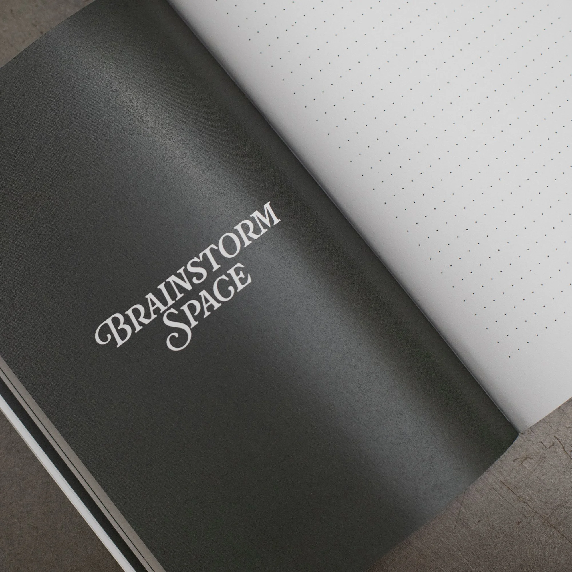 Close-up of a black and white printed decision or reference sheet with the words 'PRISM PRISM SPACE' visible, partially turned page revealing a dot pattern and textured surface, lying on a gray carpeted floor.