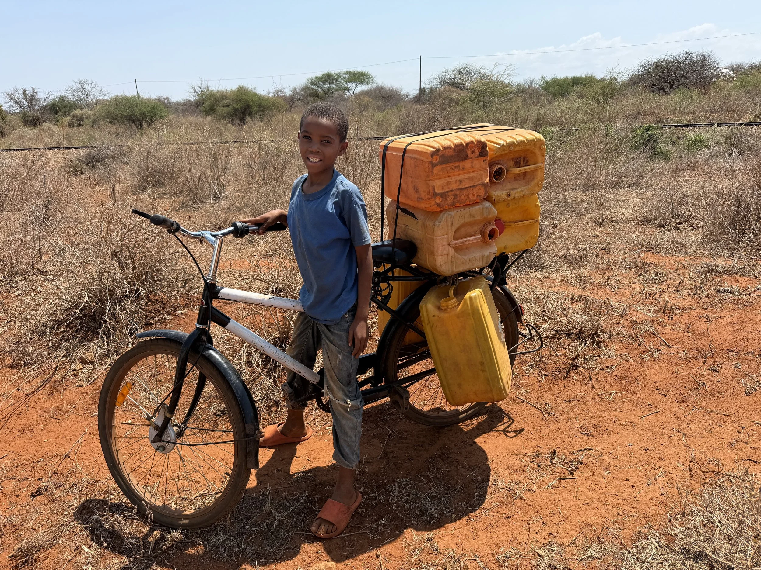Young boy in route to use the water and ride it back home (picture taken with his consent).