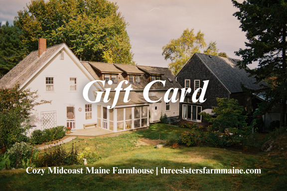 Photo of a large rural farmhouse with a white and dark exterior, surrounded by trees and a lawn, with the text 'Gift Card' overlaid, and the website 'threesistersfarmmaine.com' at the bottom.