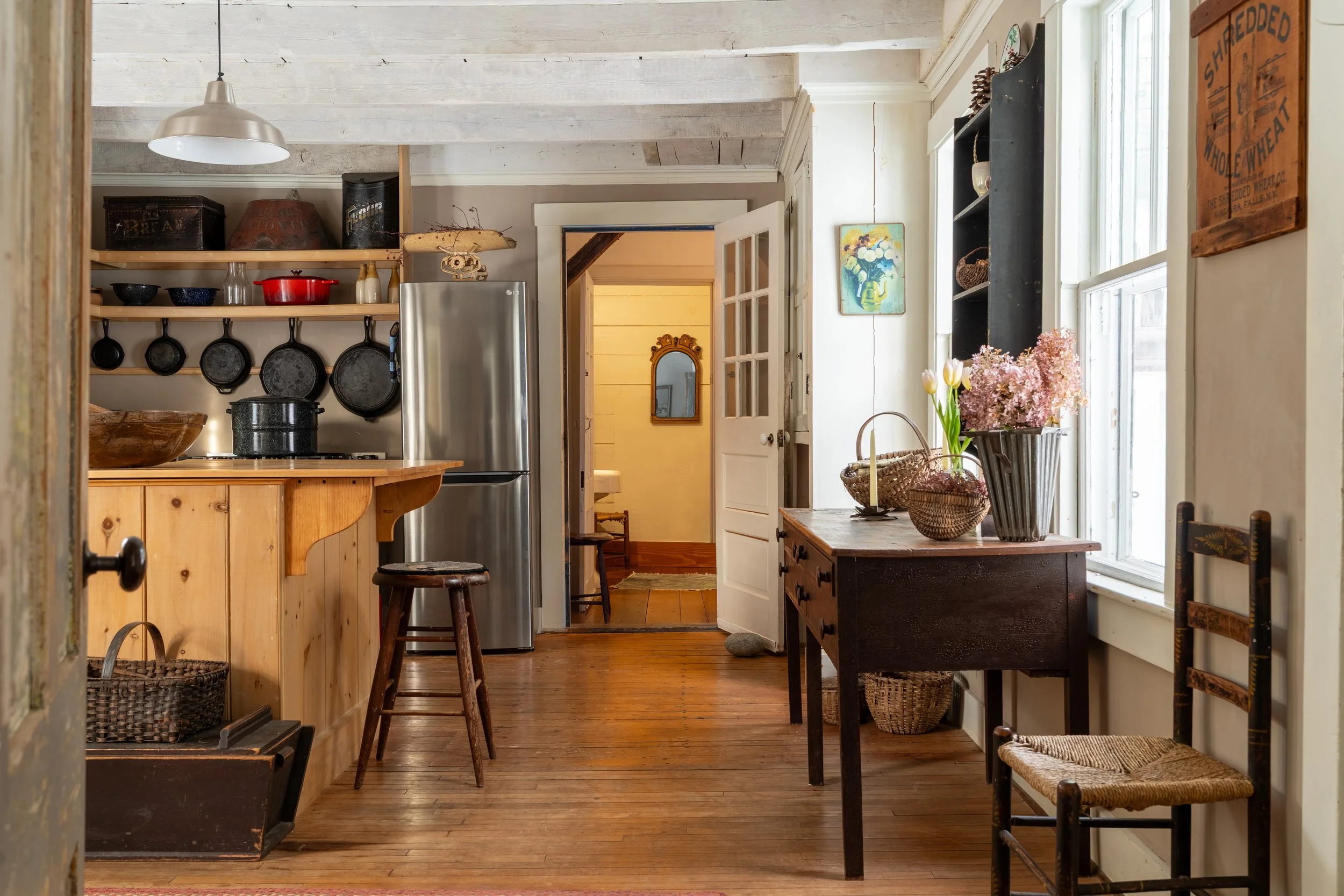 The rustic farmhouse kitchen at Three Sisters Farm, with cast-iron cookware and open shelving.