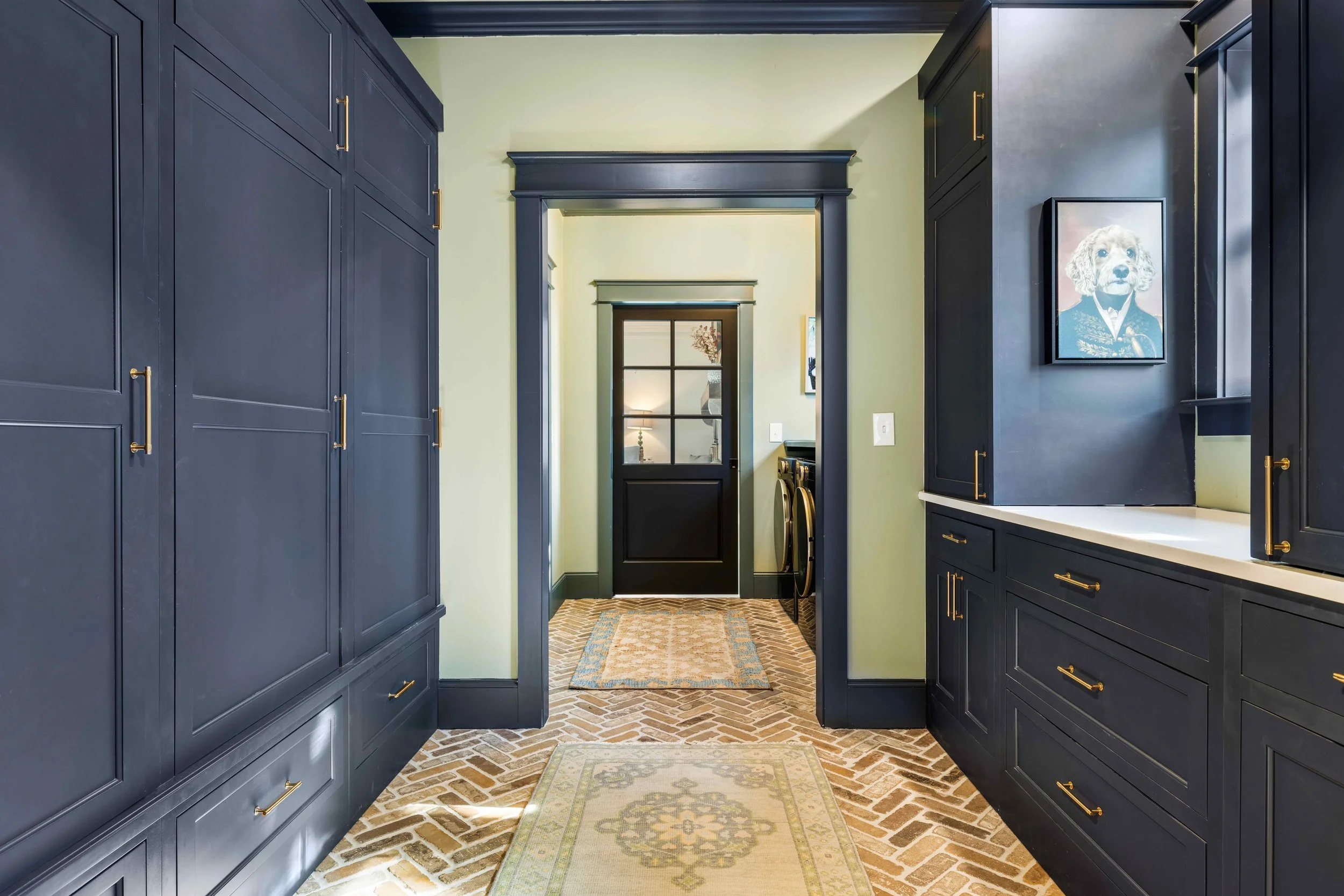 mudroom and laundry room renovation with custom cabeintry and herring bone brick floors with craftsman style trim
