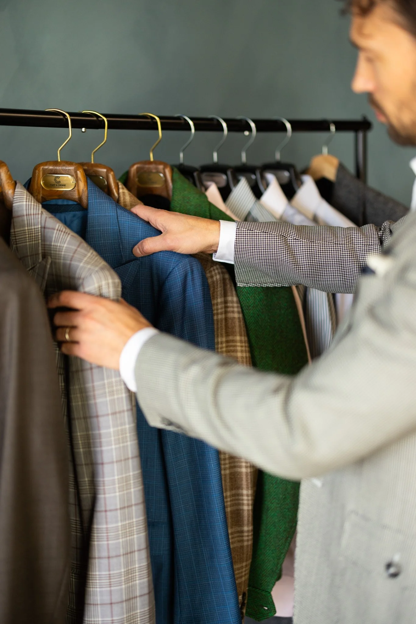 Hand selecting fabric and finishing details for custom clothing.