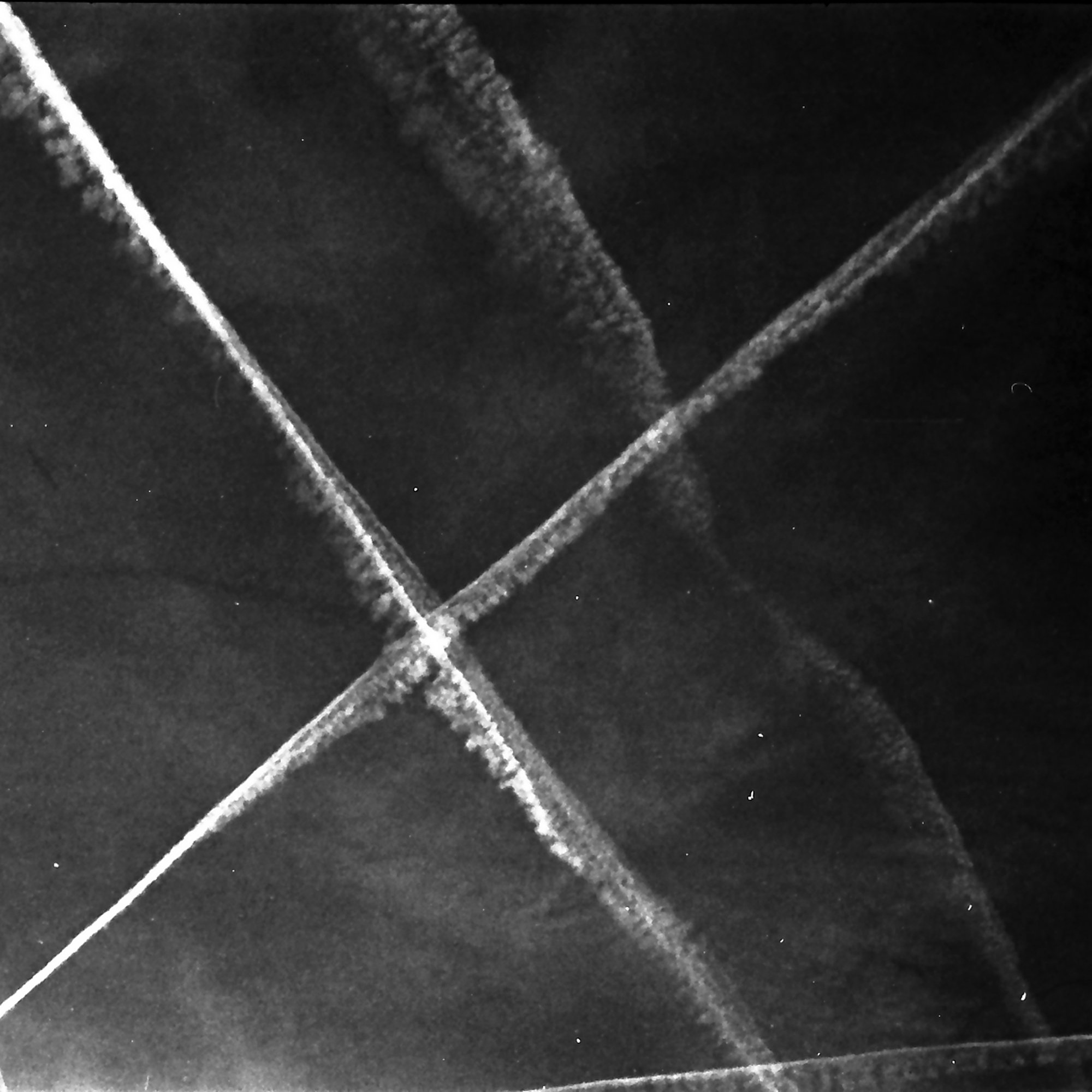 Kondensstreifen am Himmel – analoge Schwarzweiß-Fotografie aus der Serie UNDER_SKIES von Manuela Ecker