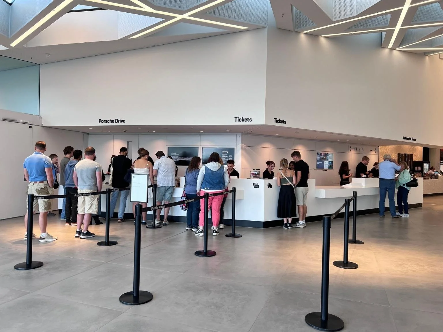 保時捷博物館購票櫃台，遊客絡繹不絕，準備進入參觀。