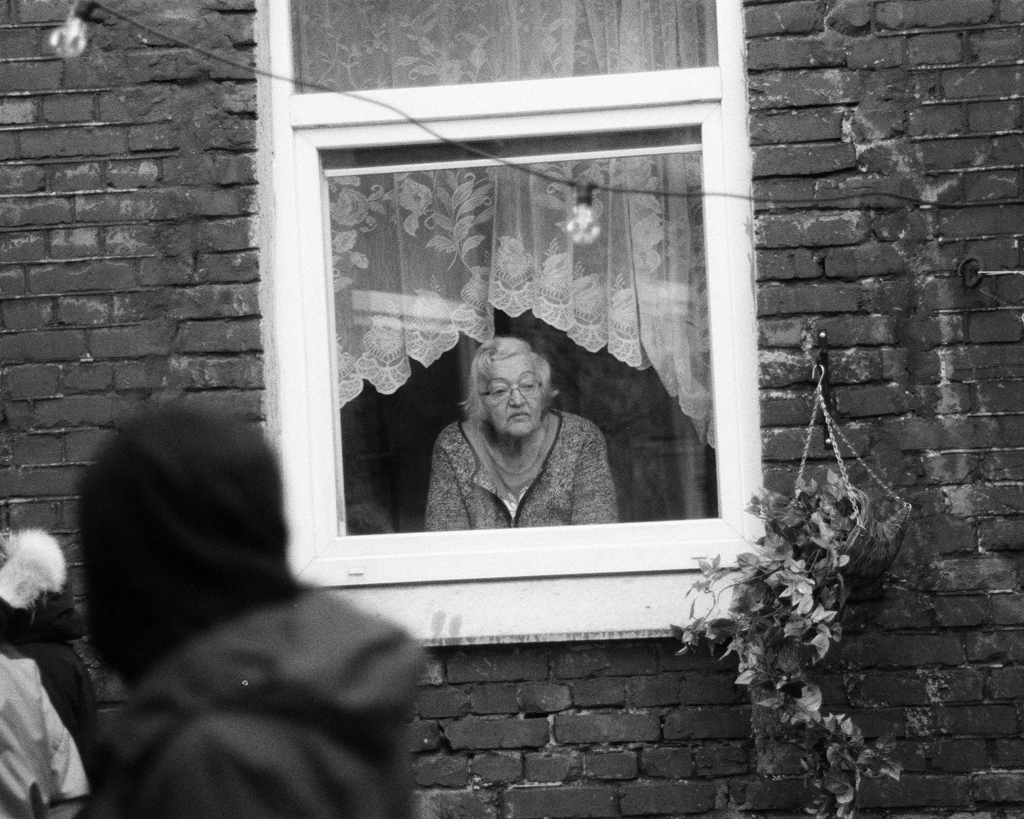 Old woman looking out o fthe window.