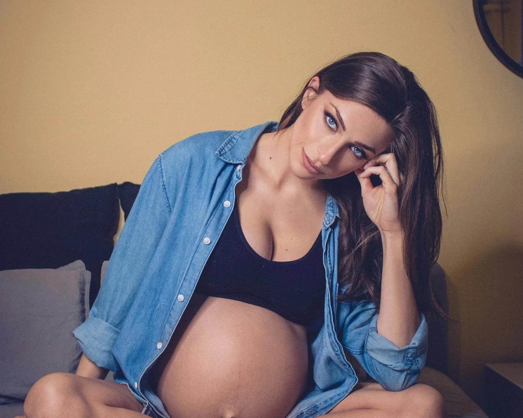 pregnant woman sitting thoughtfully, representing uncertainty and emotional complexity in parenting after trauma