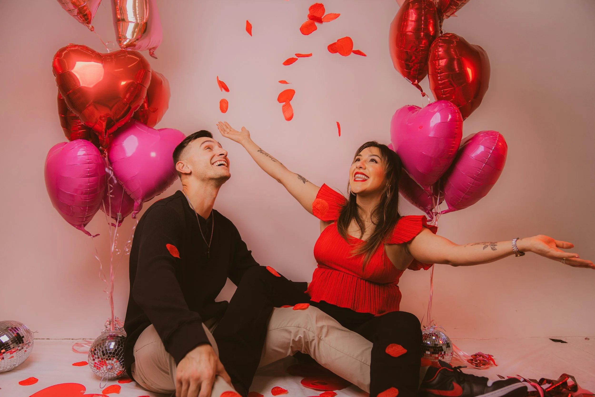 A couple surrounded by heart-shaped balloons, representing intense early romance