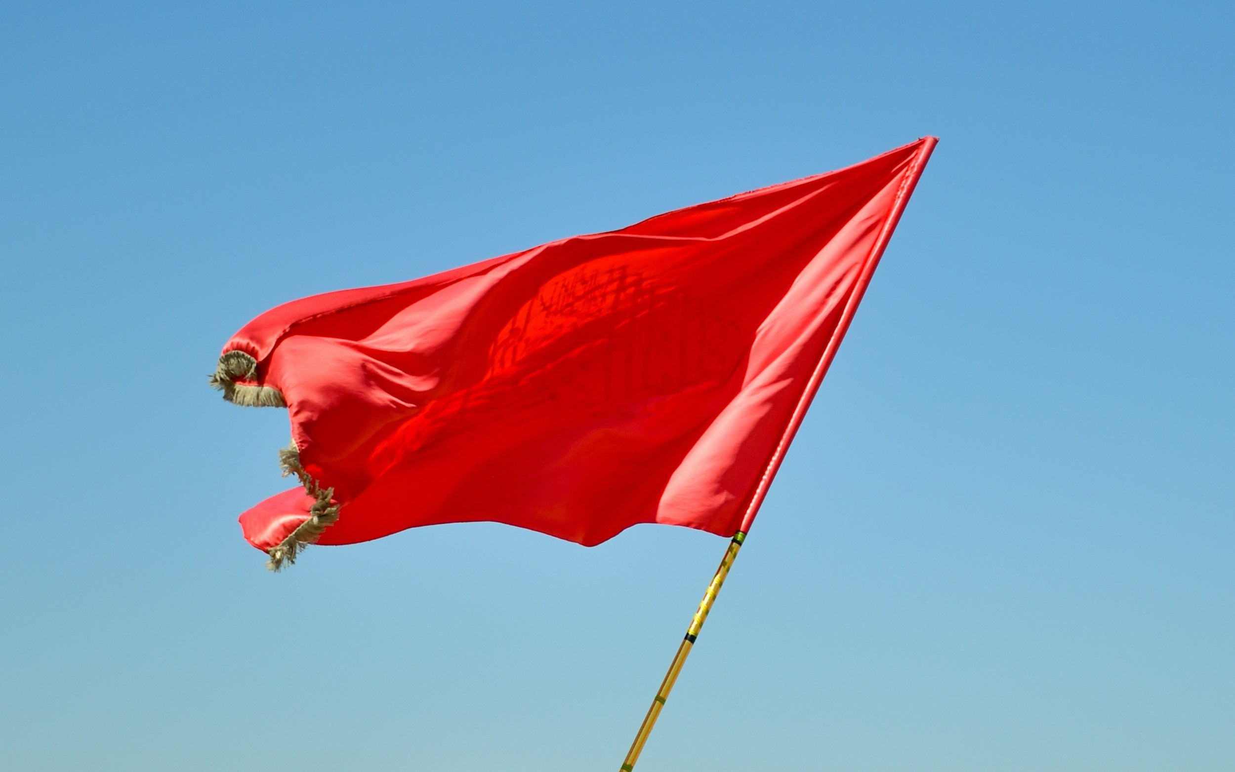 A red flag in a blue sky.