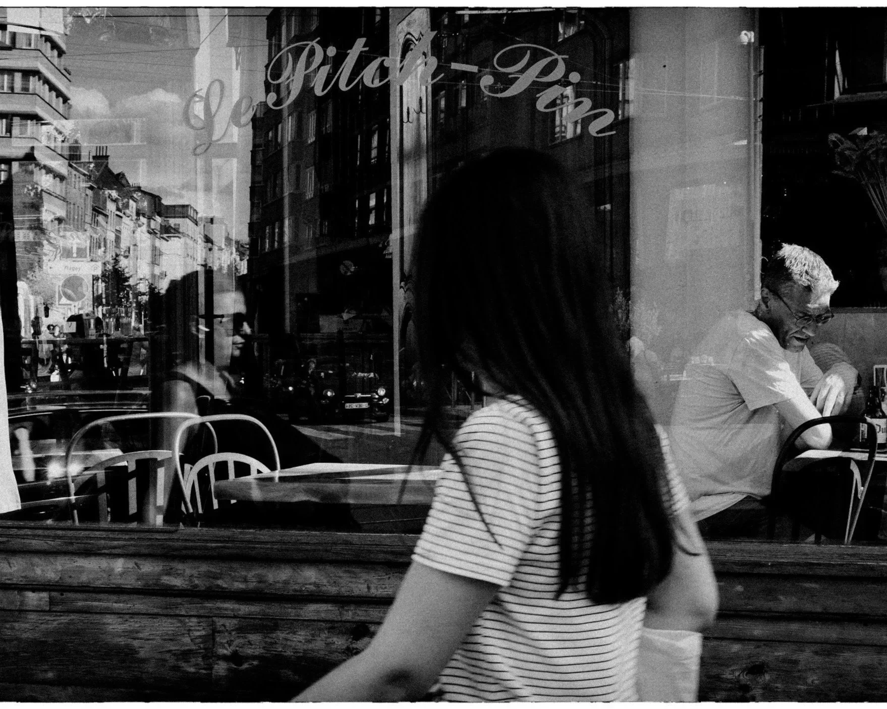 Person sitting alone by a window in black and white image symbolising fear and surveillance.