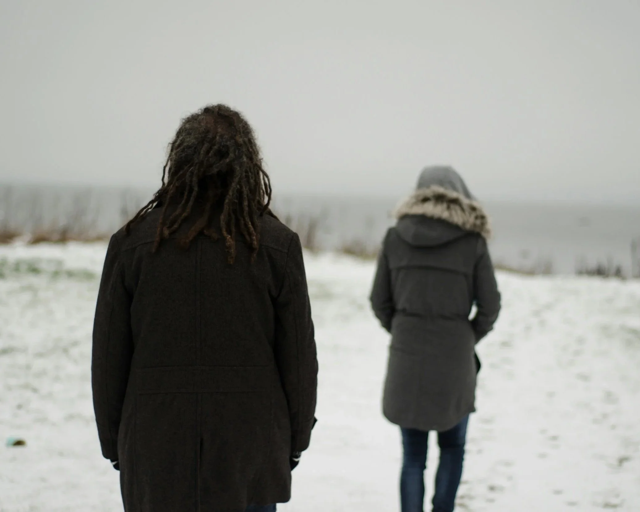 an image of a person walking away from another person looking at them