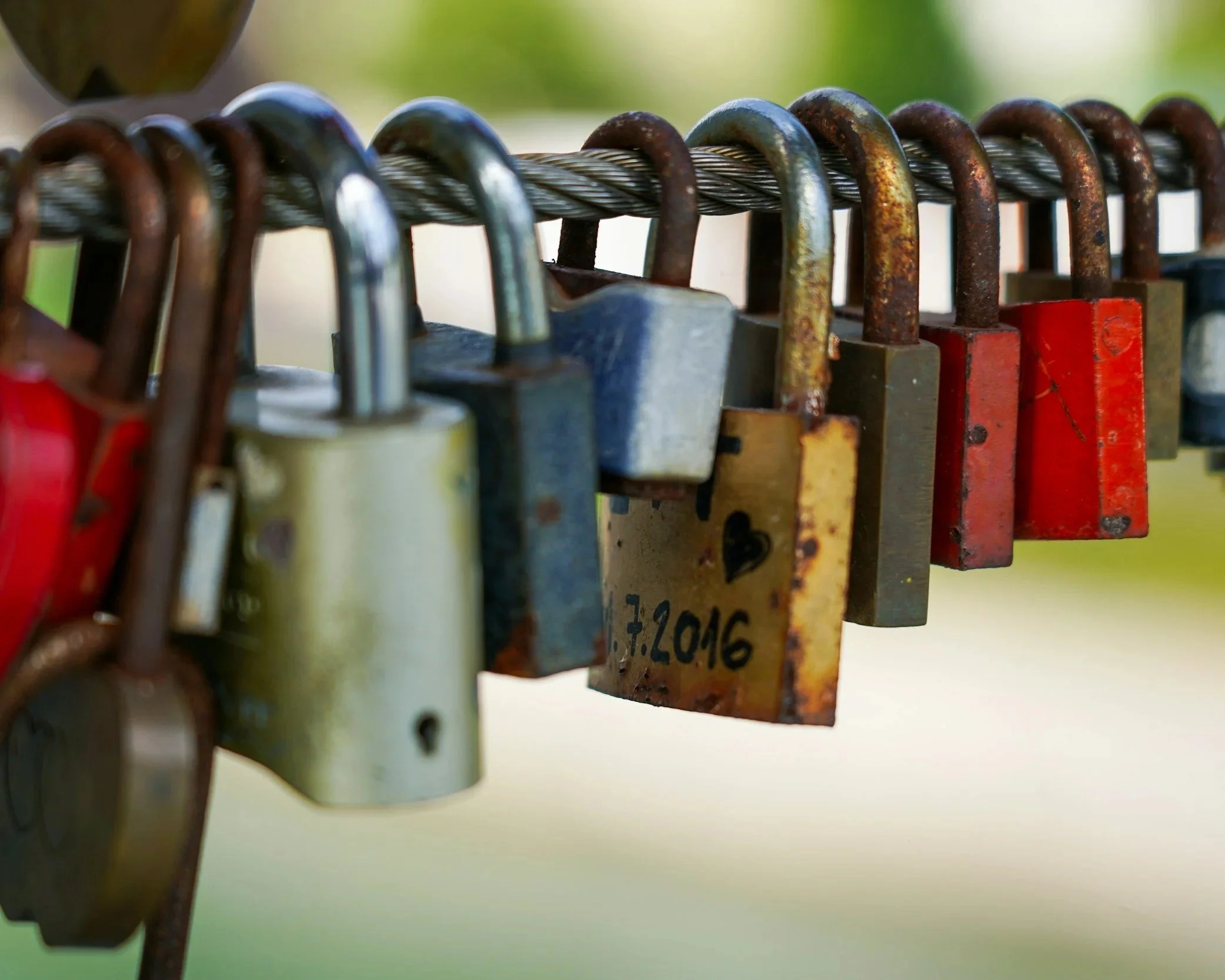 Row of padlocks hanging together symbolising emotional entrapment and trauma bonding.