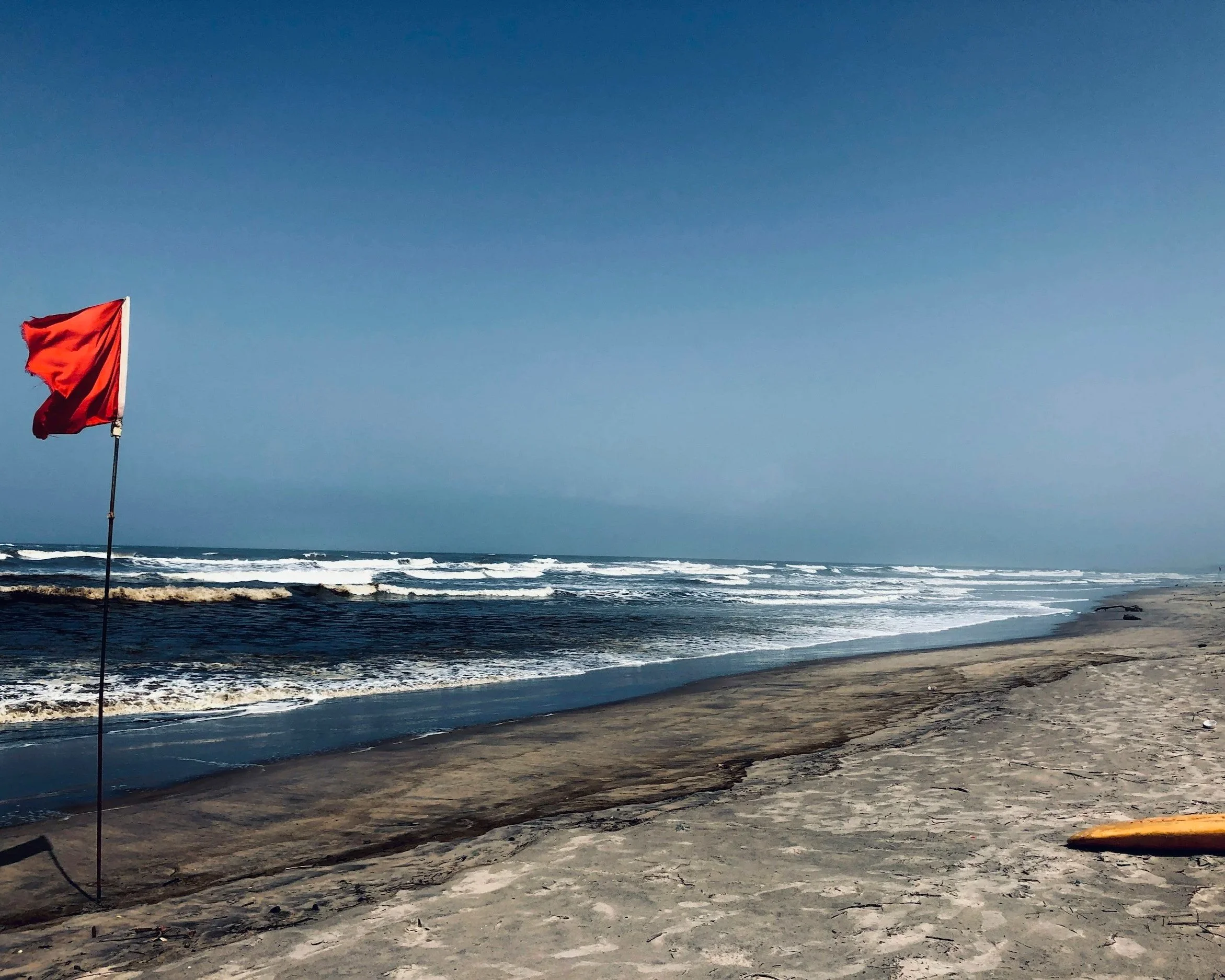 Red flag on a beach, representing warning signs in relationships