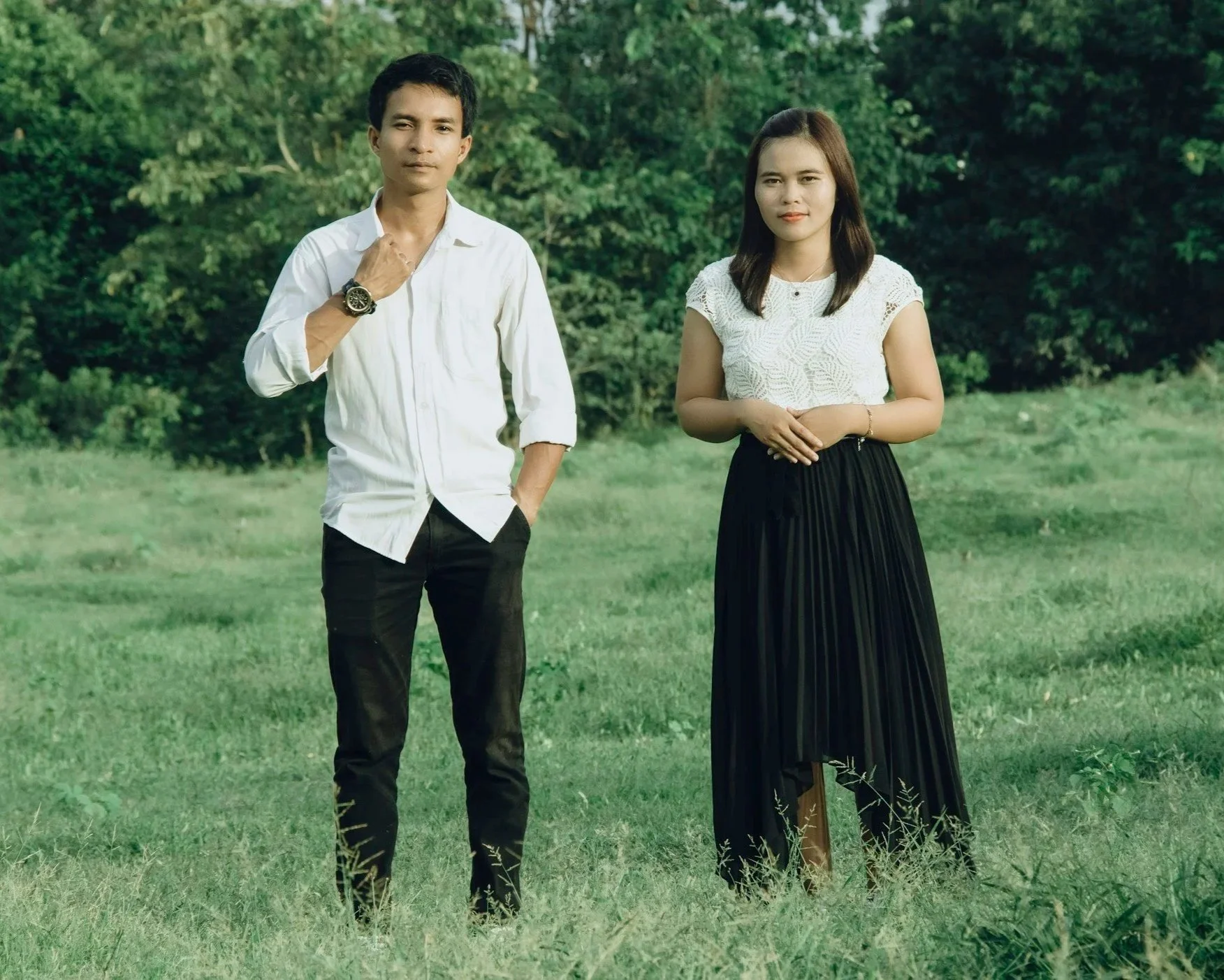 Couple standing apart outdoors appearing emotionally disconnected and tense.