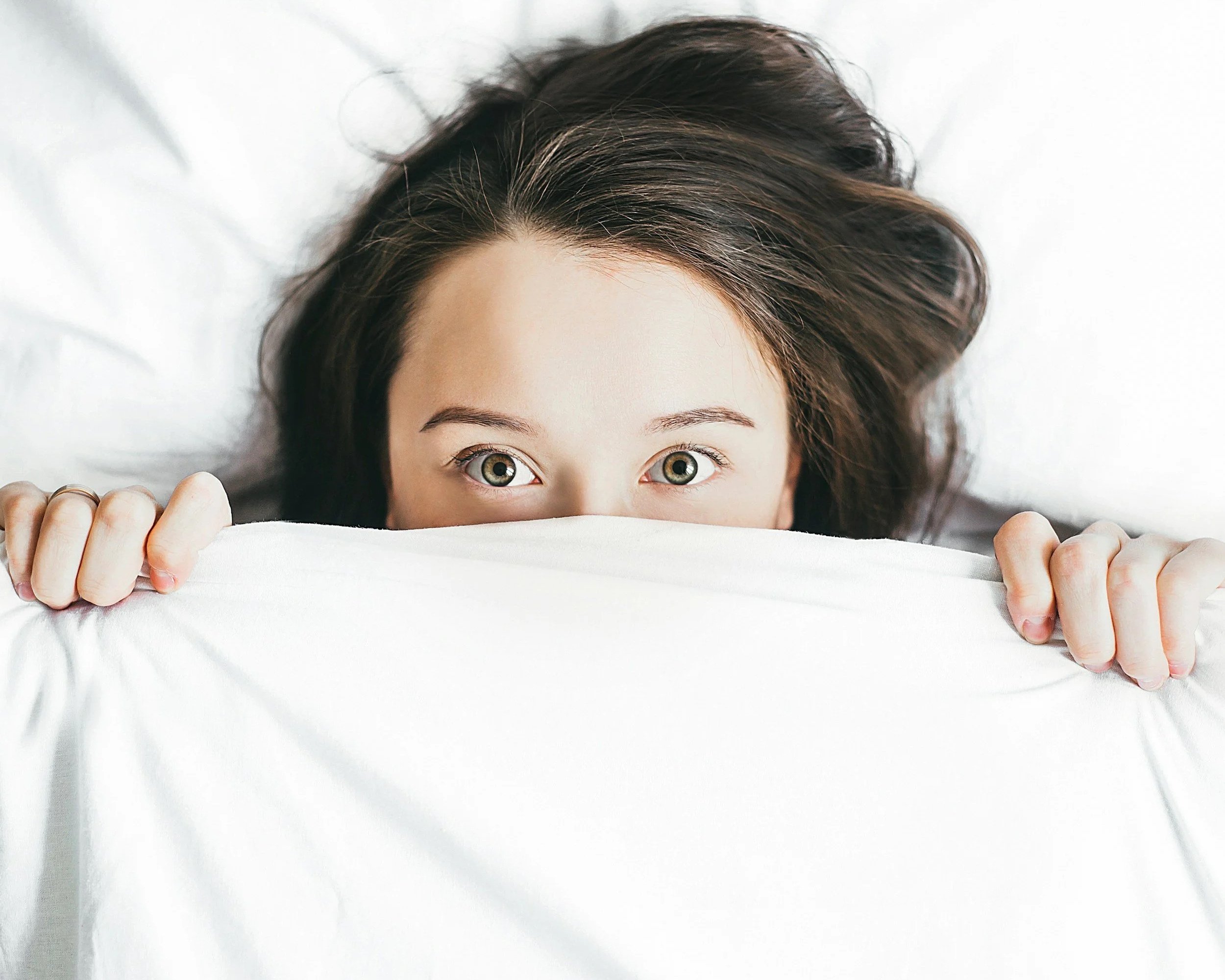 Person hiding under a sheet symbolising feeling overwhelmed and not enough