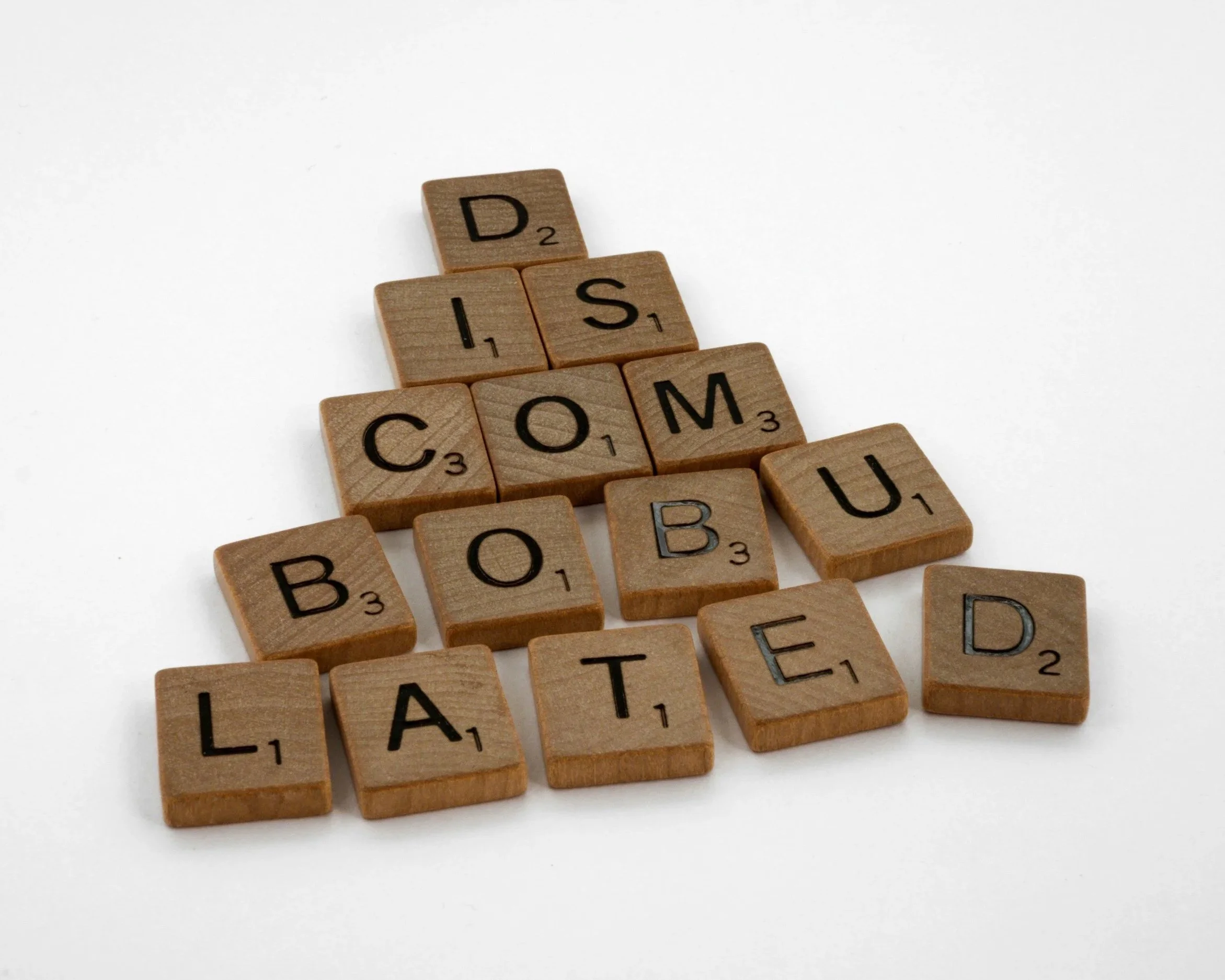 Wooden letter blocks spelling “discombobulated” stacked on a table.