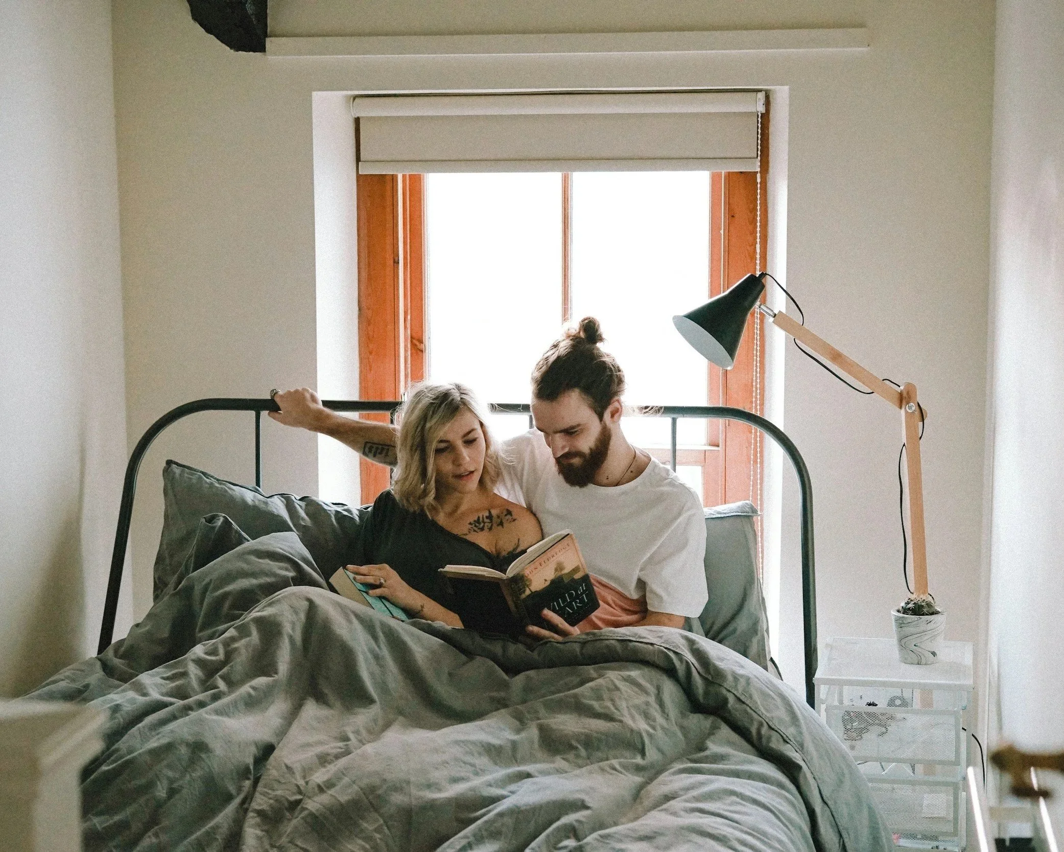 Couple sitting together in bed, representing intense early connection in relationships