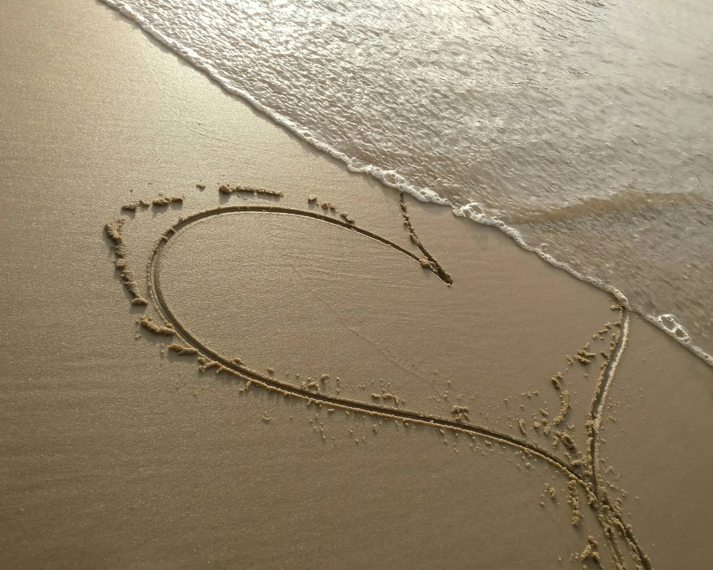 Heart drawn in sand, representing beliefs about love and self-worth