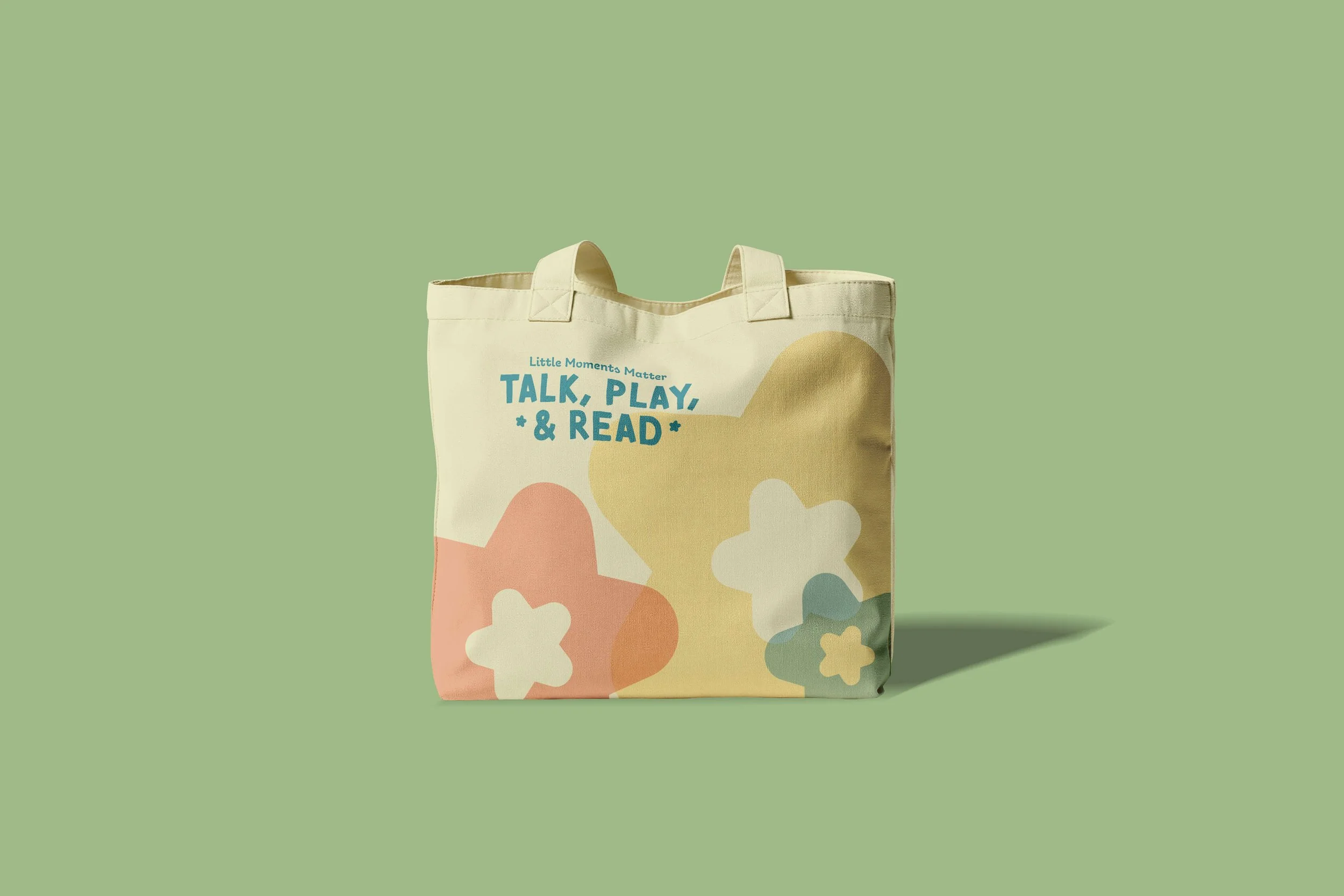 Talk, Play, & Read tote bag mockup with soft colourful shapes and the Little Moments Matter brand message.