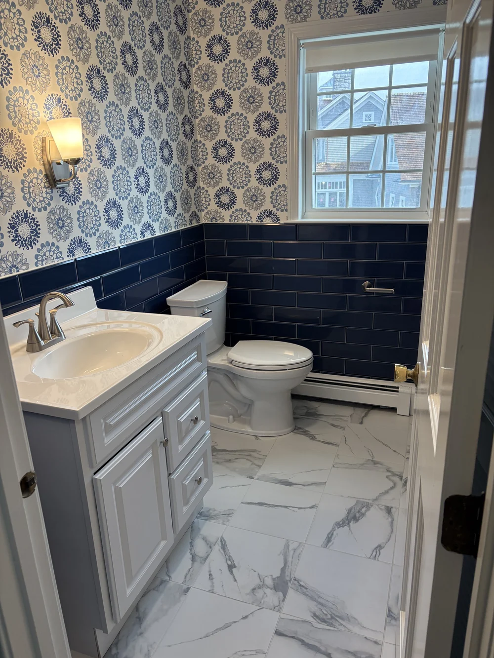 Full bathroom remodel in Plymouth, MA with blue subway tile and floral wallpaper by MSDG Construction