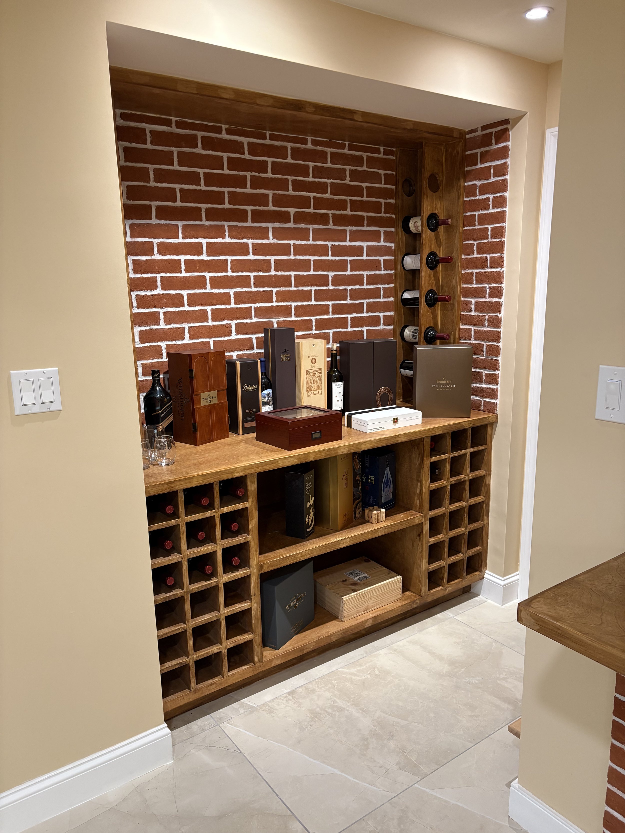 Basement bar with wine storage and brick wall — Plymouth, MA basement finishing by MSDG Construction