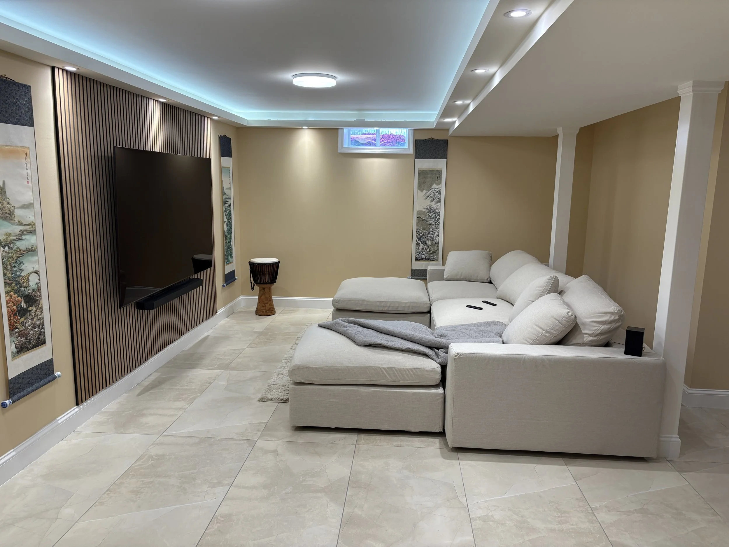 Finished basement family room with mounted TV and slat wall — Plymouth, MA basement finishing by MSDG Construction