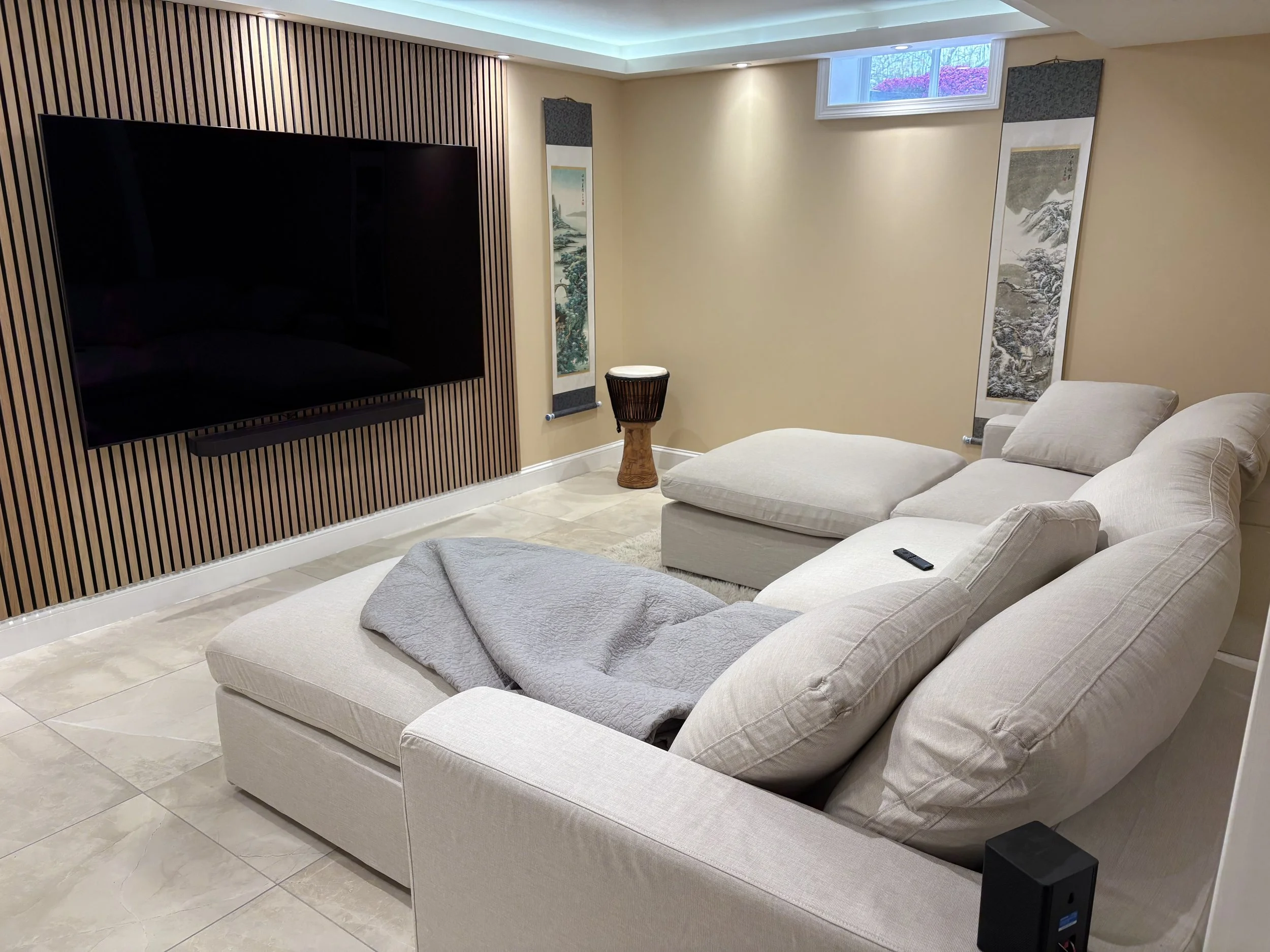 Finished basement living room with recessed lighting and sectional seating — Plymouth, MA basement finishing by MSDG Construction