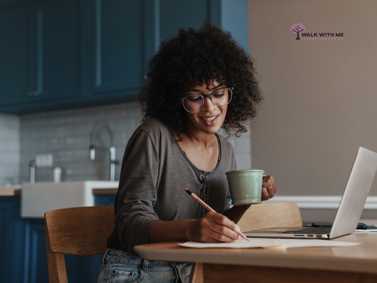 Adult sitting at home with a laptop during an online therapy appointment