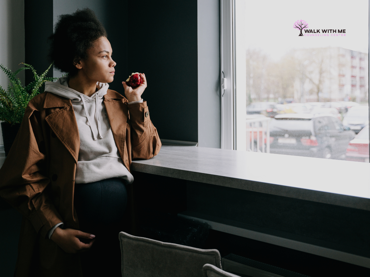 Woman staring blankly out a window, looking flat and disconnected