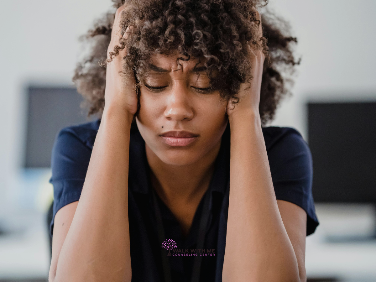 Woman rubbing her temples, looking frustrated and overwhelmed after snapping at someone