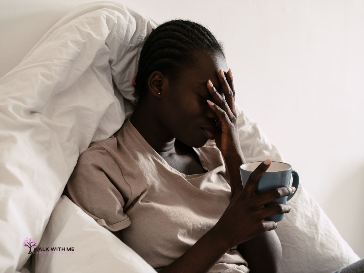 Woman sitting on a couch with tea, looking tense and unable to settle despite free time
