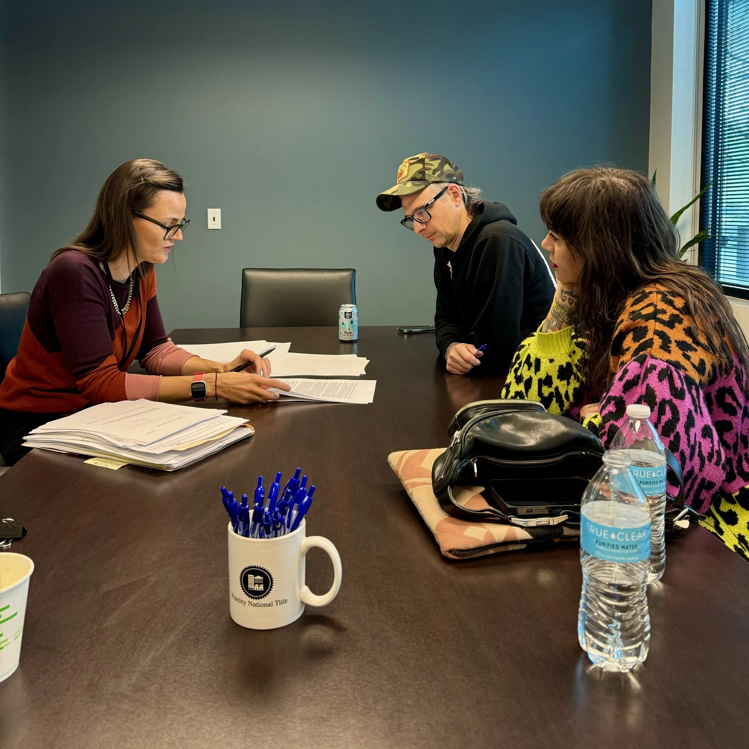 Man and woman signing paperwork at Fidelity National Title