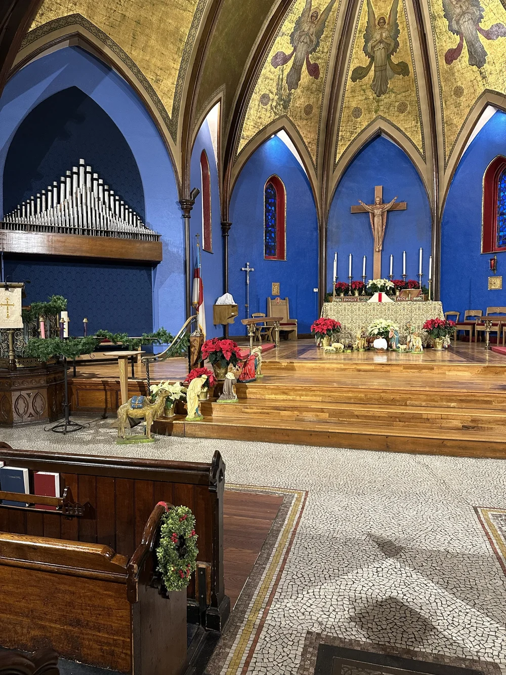 The sanctuary of St. John's decorated for Christmas Eve with poinsettias, greens, and the nativity