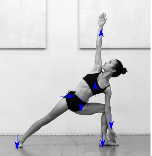 A woman practicing yoga in a side pose with one arm extended upward, one hand on the ground, and her legs spread wide apart.