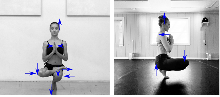 Two women practicing yoga indoors, both in a seated meditation pose with legs crossed, hands together in prayer position, and eyes closed.